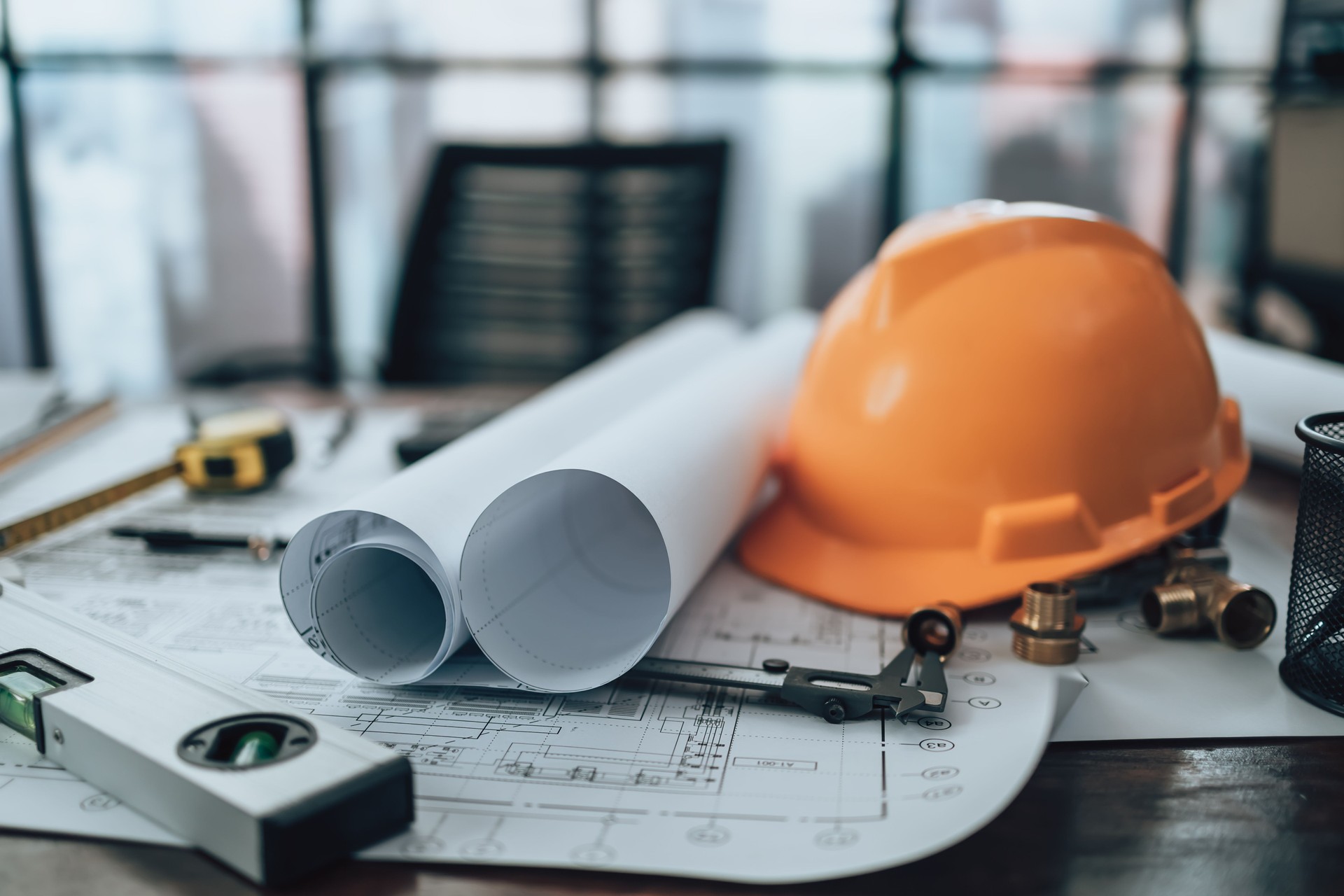 Rolls of paper layout factory, industry on engineering drawings. Calculator, triangle ruler, safety glasses, compass, vernier caliper on Blueprint. Engineer, Architect, Industry and factory concept.